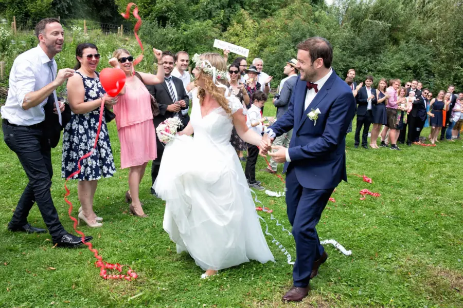 Hochzeitsfotograf hält einen emotionalen Moment auf einer Hochzeit in München fest. Die Gäste feiern das Brautpaar.